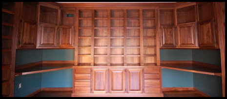 A premier floor-to-ceiling solid wood library masterpiece featuring custom French entry doors, shown in premium Walnut.