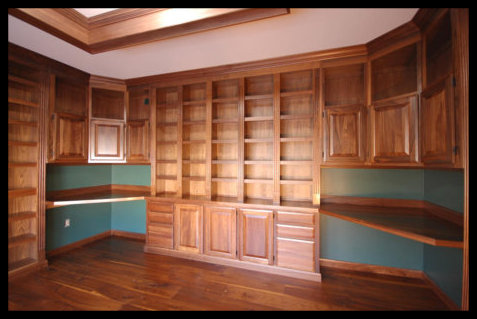 Custom solid walnut floor-to-ceiling cabinetry featuring a five-bay open bookcase atop seamless base cabinets.