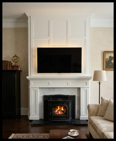 12ft tall white fireplace surround; Mission style pilasters, custom mantel, and staggered wall paneling with TV.