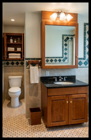 Custom Cherry wood bathroom suite featuring a raised panel vanity with a matching handcrafted medicine cabinet and coordinated wood light bar.