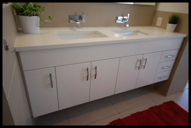 Premier showcase of a custom white floating bathroom vanity featuring five doors, three drawers, and a premium double bowl inlaid sink.