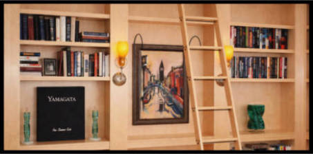 Custom L shaped maple bookcase with rolling ladder and sconce lights.