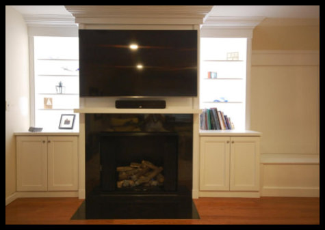 Custom 14ft wide home entertainment center featuring handcrafted solid wood cabinetry and built-in bookcases flanking a central fireplace.