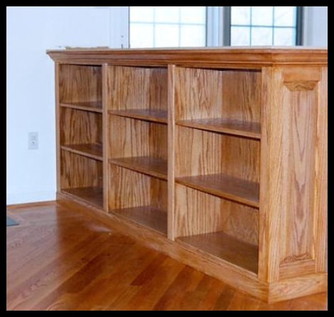 Custom 8-foot wide red oak built-in with fixed shelving and raised-panel side detailing, standing 38 inches tall.